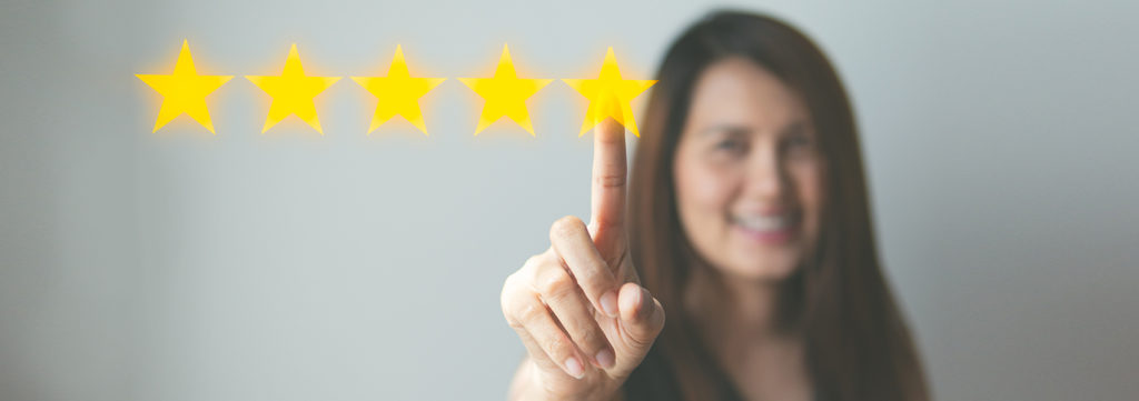 A woman pointing to the 5th of 5 yellow stars to signify successful marketing.