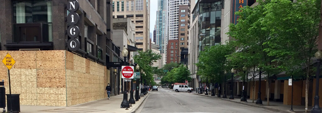 Photo of a deserted Rush Street in Chicago's Gold Coast with boarded up windows during the pandemic.