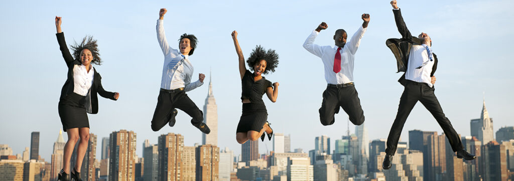 5 professionals jumping up in the air with joy.