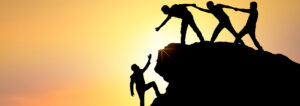 figures reaching out to help a man climbing up a mountain